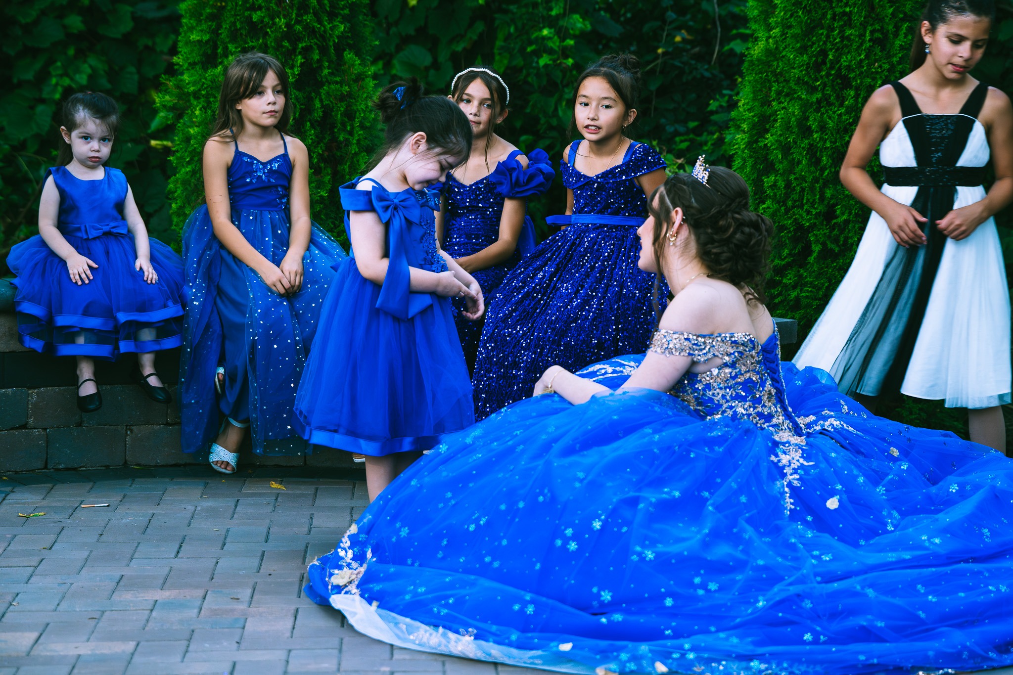 Quinceañera court sharing a candid moment in blue dresses