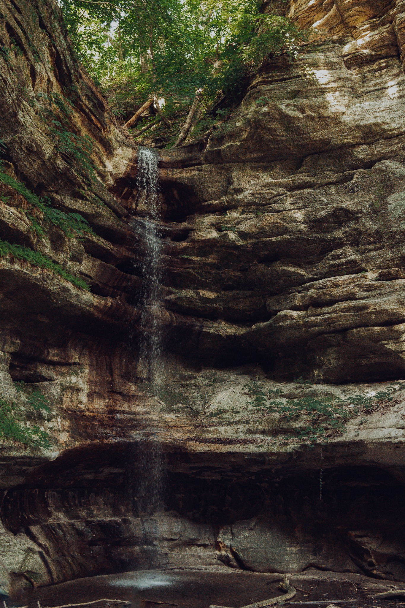 Waterfall running down layered rock walls